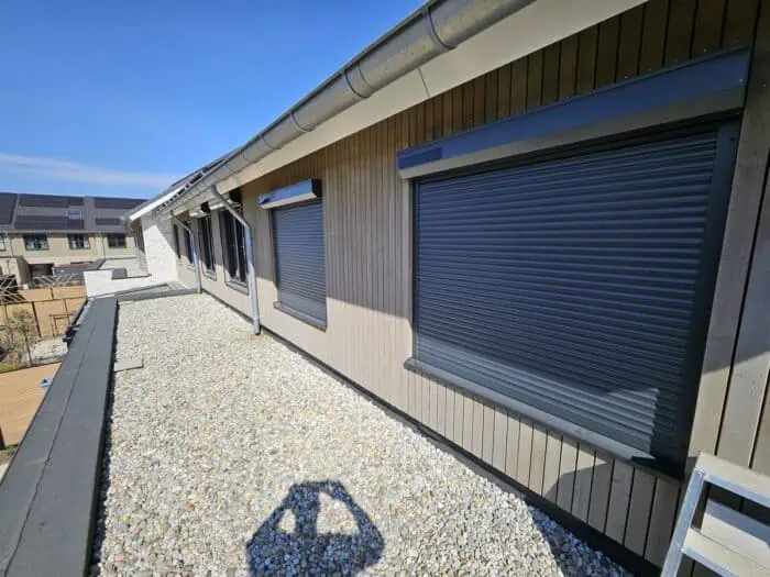 Solar rolluiken met eigen zonnepanelen aan een houten gevel
